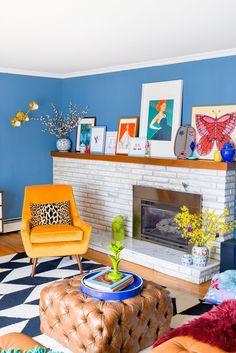 a living room with blue walls and yellow chairs in the corner, an orange chair sits on a black and white checkered rug