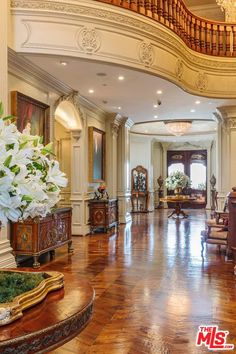 a large foyer with wooden floors and white flowers