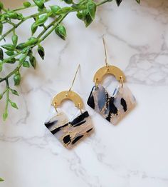 a pair of earrings sitting on top of a marble counter