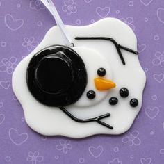 a snowman ornament with black and white frosting on it's face