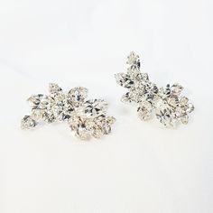 two pairs of diamond earrings on a white background