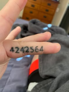 a person's hand with a small tattoo saying 422564 on it