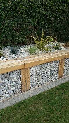 a wooden bench sitting next to a stone wall