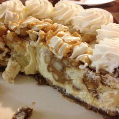 a piece of pie with white frosting and nuts on top