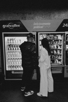 two people standing in front of a vending machine