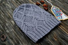 a knitted hat sitting on top of a wooden table next to an ornament