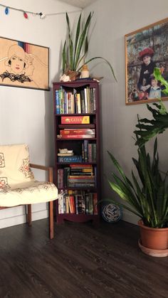 a living room filled with lots of books and plants on top of a wooden floor