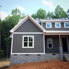 a house is being built in the middle of some trees and dirt on the ground