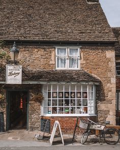 an old brick building with a bicycle parked in front of it and other items outside