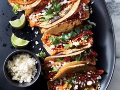 some tacos and rice on a black plate