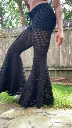 a woman in black crochet pants standing on the ground