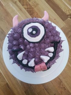 a purple cake with white frosting and an evil face