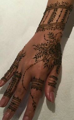 a woman's hand with henna tattoos on it