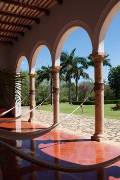 an outdoor hammock area with palm trees in the background