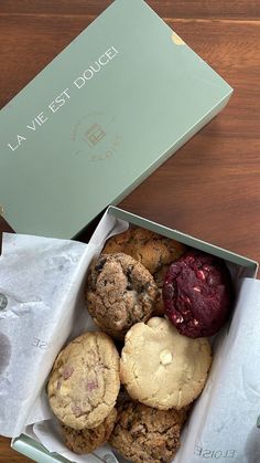 a box filled with assorted cookies on top of a wooden table