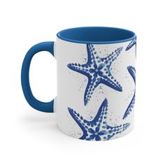 a blue and white coffee mug with starfishs on the inside, sitting in front of a white background