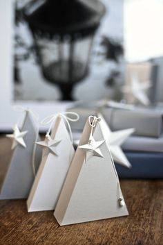 three small white christmas trees on top of a wooden table