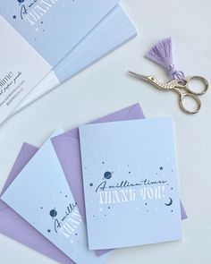 purple and white folded thank you cards with scissors next to them on top of each other