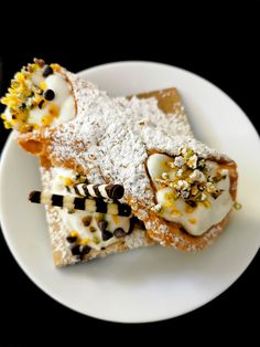 three desserts on a white plate with powdered sugar and sprinkles