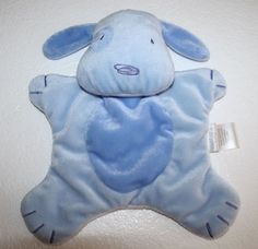 a blue stuffed animal laying on top of a white surface with a tag attached to it