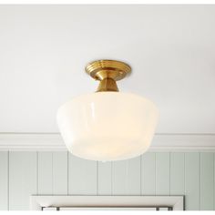 a light fixture in a bathroom with white walls and wood paneling on the ceiling