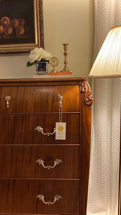 a wooden dresser with a lamp on top of it