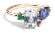 three stone ring with two different colored stones on the band and one green, blue, and