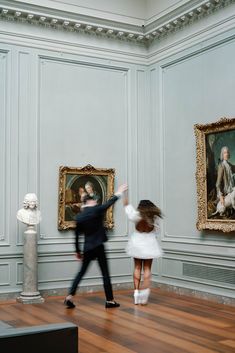 two people are dancing in an art gallery