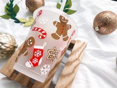 a cup that is sitting on top of a wooden stand with christmas decorations around it