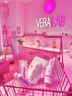 a pink shopping cart in a store filled with personal care items and hygiene products on display