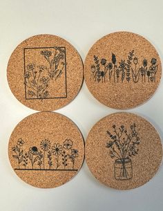 four coasters decorated with flowers and plants