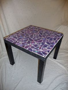 a table that has some kind of mosaic design on the top and bottom, sitting on a white sheet