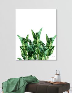 a painting of green leaves on a white wall above a bench in a living room