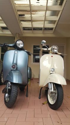 two scooters parked next to each other in a room with tile flooring