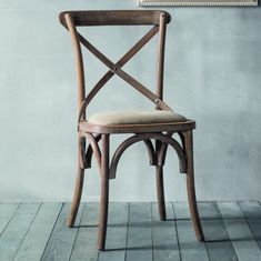 a wooden chair sitting on top of a hard wood floor next to a framed painting