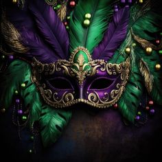 a purple and green mask with feathers on it