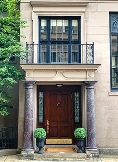 an entrance to a home with two planters on the steps