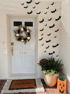 a white door decorated with bats and wreaths