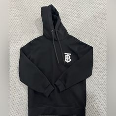 Brand New Black Hoodie With Logo Detail For Winter, Luxury Black Hoodie For Fall, Luxury Black Sweatshirt For Fall, Luxury Black Hoodie For Winter, Luxury Black Sweatshirt For Streetwear, Luxury Black Hoodie With Double-lined Hood, Luxury Black Hoodie With Ribbed Cuffs, Burberry Sweatshirt, Burberry Hoodie