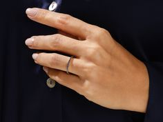 a woman's hand with two rings on her left and one ring on her right