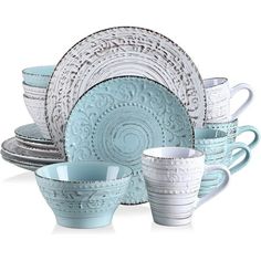 a blue and white dinnerware set on a white background with an intricate design in the center