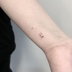 a person's arm with a small tattoo on the left side of their wrist