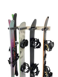 three snowboards are mounted to the side of a rack with skis on it