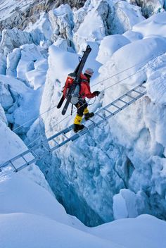 a man walking across a bridge over snow covered ground