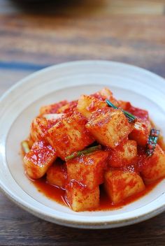 a white plate topped with tofu covered in sauce