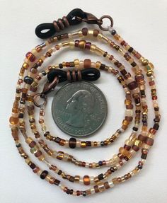 Brown, yellow, and cream hues with copper and gold make up this beaded eyeglass chain. Black rubber and copper eyeglass holders are attached at both ends. Approximately 26 or 31 inches long in total length with the beaded portion being either about 24 or 28 inches long. If you would prefer clear rubber connectors instead of black just let me know in the comment section! Also if you are wanting to use this chain for a mask let me know and I will remove the rubber connectors and swap out the lobst Gold Make Up, Beaded Eyeglass Chain, Glasses Chains, Eyeglass Chain, Glasses Chain, Nov 6, Black Rubber, A Mask, Tortoise Shell