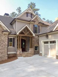 a large brick house with two garages on the front and one car door open