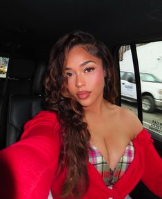 a woman sitting in the back seat of a car with her hand on her hip