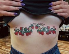 a woman's lower back tattoo with strawberries on it