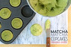 cupcakes with green frosting in muffin tins next to a spatula